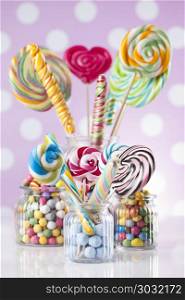 Colorful lollipops and different colored round candy and gum bal. Lollipops and sweet candies of various colors
