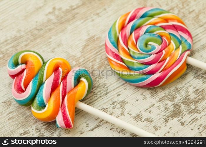 Colorful lollipops of different shapes on a wooden background