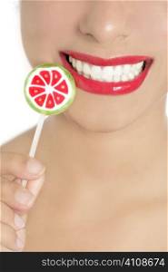 Colorful Lollypop in perfect woman teeth and red lips mouth