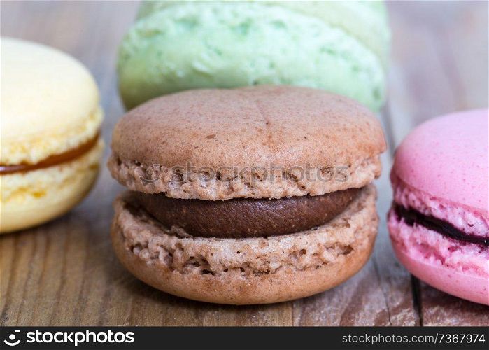 Colorful macarons on a rustic wooden macro.. Colorful macarons on a rustic wooden macro