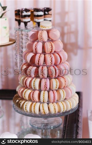 Colorful macarons stand in round transparent weight as part of candy bar sweet. Colorful macarons stand in round transparent weight as part of candy bar sweet table