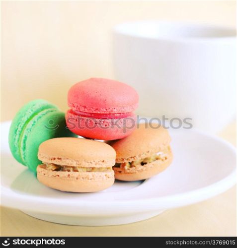 Colorful macaroons and cup of coffee with retro filter effect