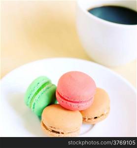Colorful macaroons and cup of coffee with retro filter effect