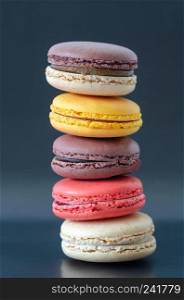 Colorful macaroons are on the dark background,