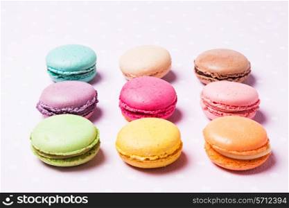 Colorful macaroons - french dessert over pink polka dot napkin