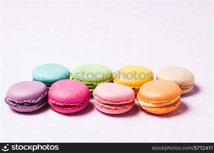 Colorful macaroons - french dessert over pink polka dot napkin