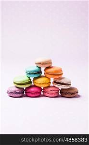Colorful macaroons - french dessert over pink polka dot napkin. The Colorful macaroons
