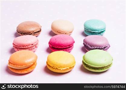 Colorful macaroons - french dessert over pink polka dot napkin. The colorful macaroons