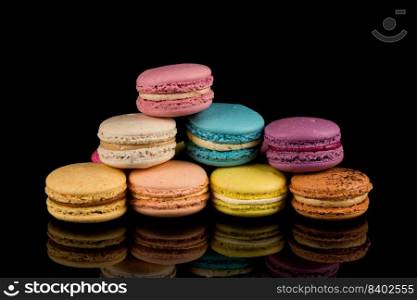 Colorful macaroons over a black background with reflection
