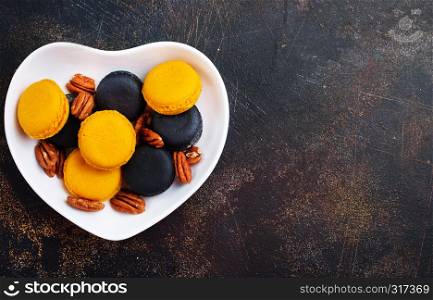 colorful macaroons with dry pecan in bowl