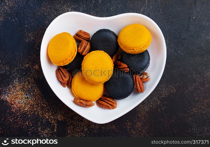 colorful macaroons with dry pecan in bowl