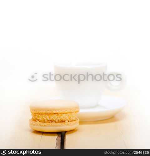 colorful macaroons with espresso coffee over white wood table
