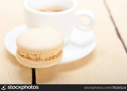 colorful macaroons with espresso coffee over white wood table