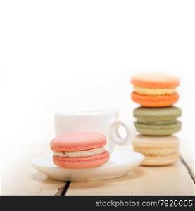 colorful macaroons with espresso coffee over white wood table