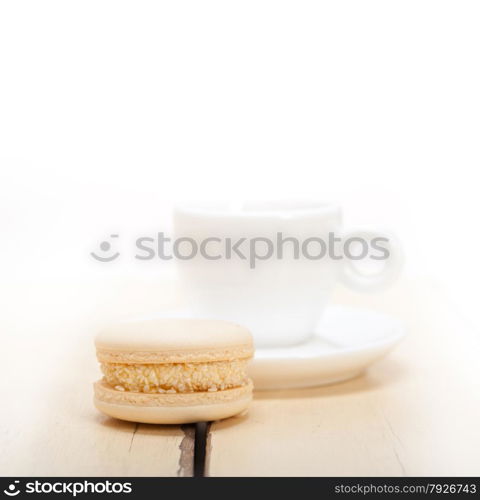 colorful macaroons with espresso coffee over white wood table