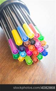 Colorful magic pens on wooden table, stock photo