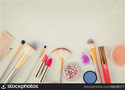 Colorful make up and brushes flat lay top view border with copy space, retro toned. Colorful make up flat lay scene