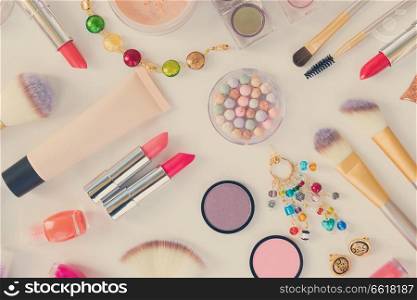 Colorful make up and brushes products top view flat lay pattern on white background, retro toned. Colorful make up flat lay scene