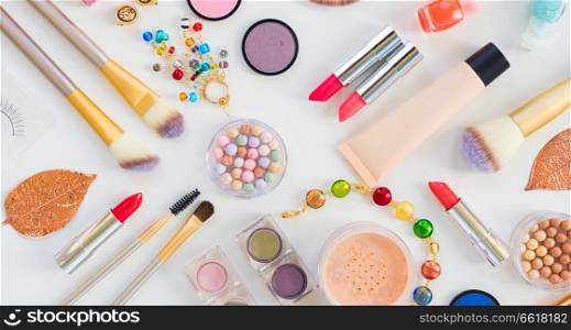 Colorful make up products flat lay scene on white background. Colorful make up flat lay scene