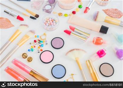 Colorful make up products flat lay scene on white background. Colorful make up flat lay scene