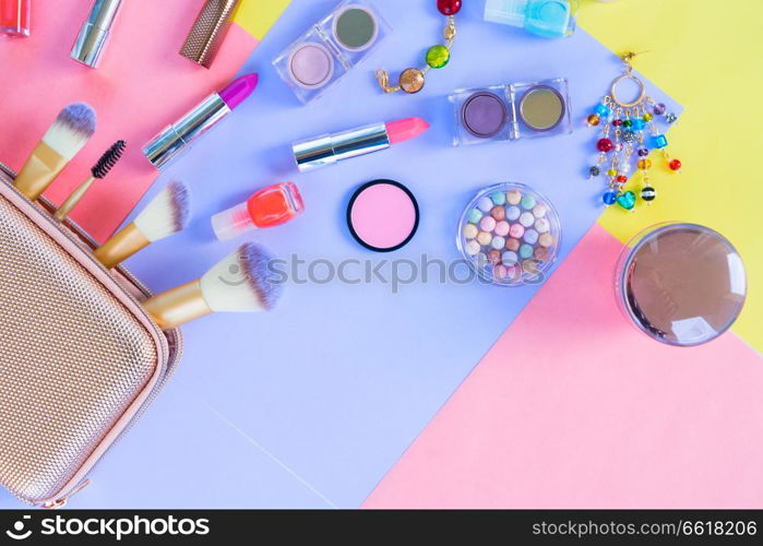 Colorful make up products pop art flat lay scene with copy space, pink and blue shades. Colorful make up flat lay scene