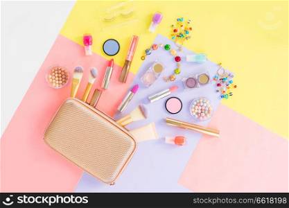 Colorful make up products with golden pursue pop art flat lay scene. Colorful make up flat lay scene