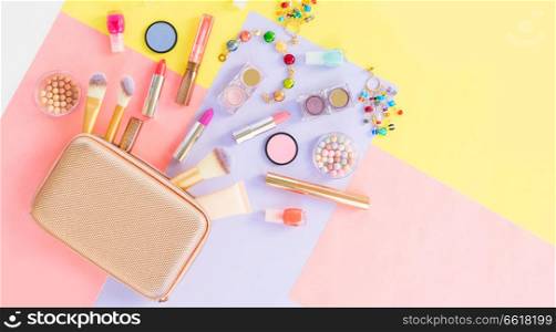 Colorful make up products with golden pursue pop art flat lay scene. Colorful make up flat lay scene