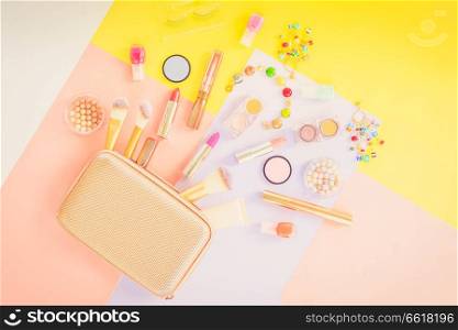 Colorful make up products with golden pursue pop art flat lay scene, retro toned. Colorful make up flat lay scene