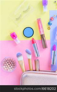 Colorful make up products with pursue pop art flat lay scene. Colorful make up flat lay scene