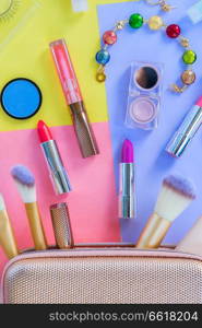 Colorful make up products with pursue pop art top view flat lay scene. Colorful make up flat lay scene