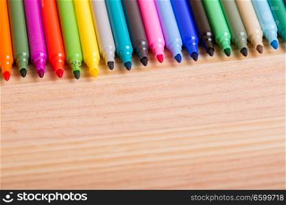 Colorful markers pens on a wooden table