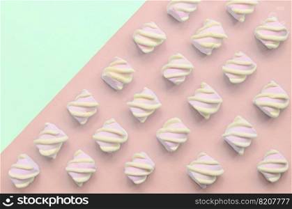 Colorful marshmallow laid out on turquoise and pink paper background. pastel creative textured pattern. minimal.. Colorful marshmallow laid out on turquoise and pink paper background