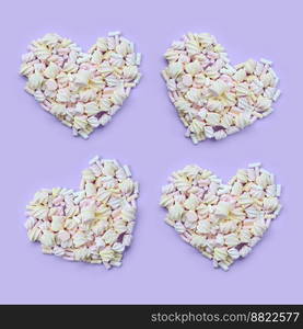 Colorful marshmallow laid out on violet and pink paper background. pastel creative textured hearts. minimal.. Colorful marshmallow laid out on violet and pink paper background. pastel creative textured hearts. minimal