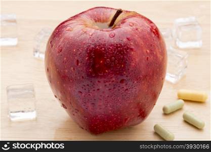 Colorful medicine capsules and red apple. Colorful medicine capsules and red apple on wooden background