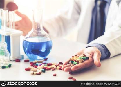Colorful medicine pills and tablets in pharmaceutical lab. Concept of medical technology research and development for future cure of illness.. Medicine pills and tablets in research lab.