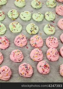 Colorful meringues on baking paper straight out of the oven.