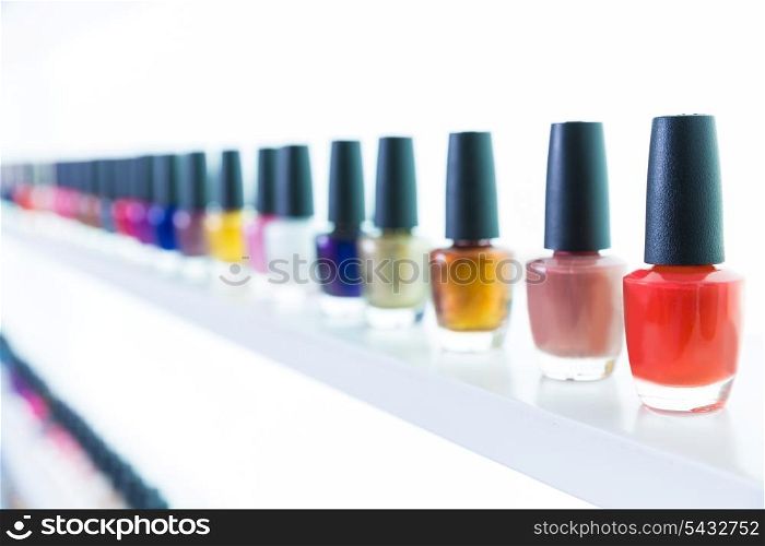 colorful nail polish colors in a row at nails saloon on white background