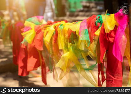 Colorful of Fabric in three colors tied to a tree background with Thai Style Three Color Fabric for Thai Religion believe and Represent God and Ghost Concept.