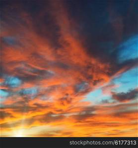 Colorful orange and blue dramatic sky with clouds and shining sun