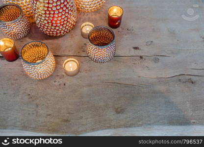 colorful orange candle holders on wooden table arabic design sparkles. colorful orange candle holders on wooden table arabic design