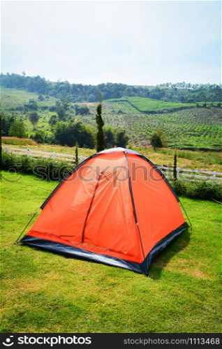 Colorful orange tent camping in row beautiful on green grass meadow for tourist travel relax outdoor holiday time