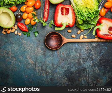 Colorful organic vegetables with wooden spoon , ingredients for salad or filling on rustic wooden background, top view. Healthy food or diet cooking concept.