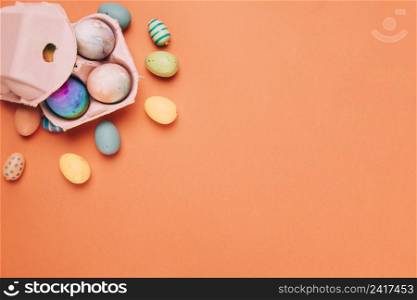 colorful painted easter eggs carton box orange background