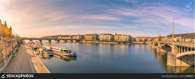 Colorful panorama with the Vltava river, its bridges and the buildings of Prague city, on a sunny day of March.