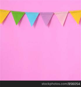 Colorful party flags hanging on pink background, birthday, anniversary, celebrate event, festival greeting card background