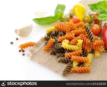 Colorful pasta on white with tomatoes and spices