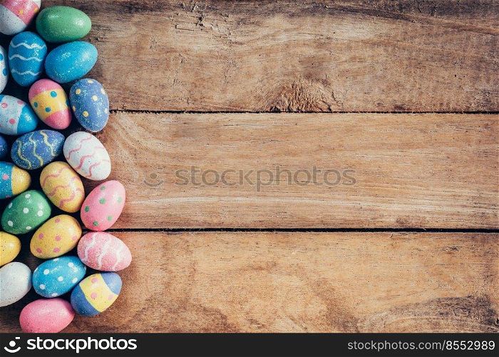 Colorful pastel easter eggs on wooden background with space. Vintage toned.