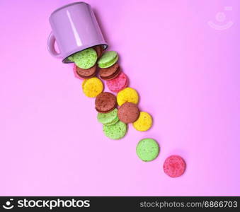 Colorful pastry made of egg whites and almond flour on a pink background, French cookies macaron