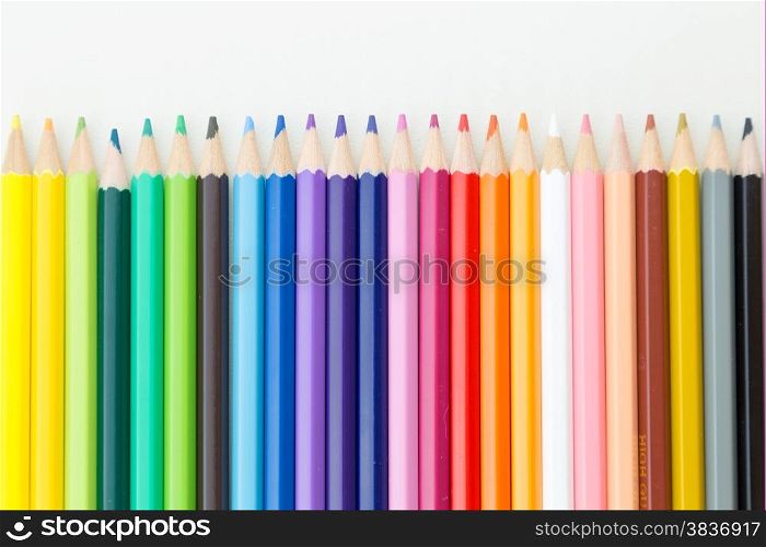 Colorful pencil crayons on white desktop