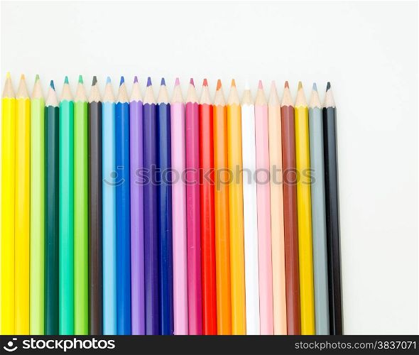 Colorful pencil crayons on white desktop